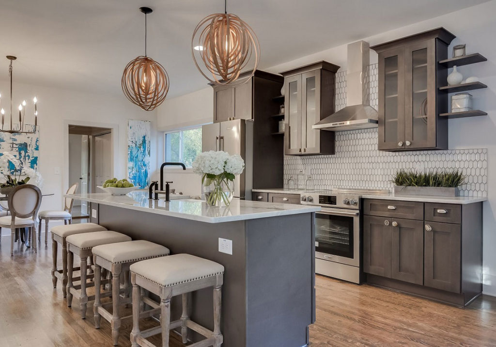 Kitchen with grey island and pendant lights by Gold Cabinets & Countertops